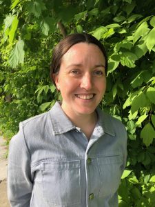 Ashley Culver stands in front of greenery.
